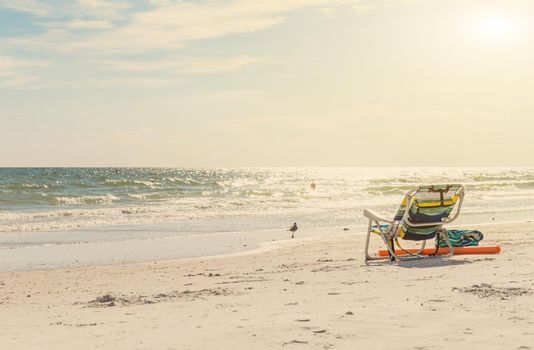 landscape of ocean and beach with chair and bag