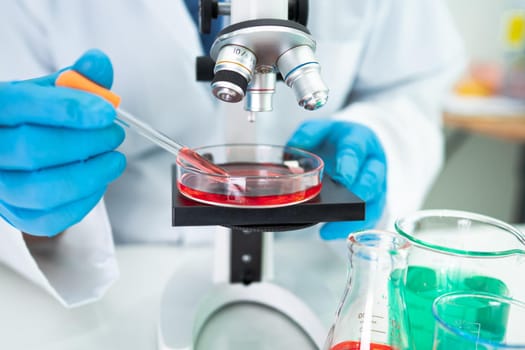 Asian scientist biochemist or microbiologist working research with a microscope in laboratory. For protect outbreak Coronavirus Covid19, bacteria and germs.