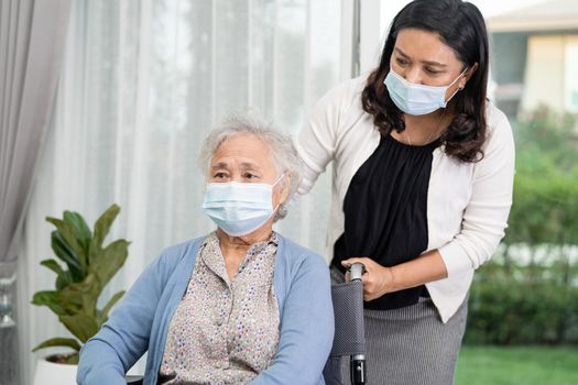 Help Asian senior or elderly old lady woman sitting on wheelchair and wearing a face mask for protect safety infection Covid-19 Coronavirus.