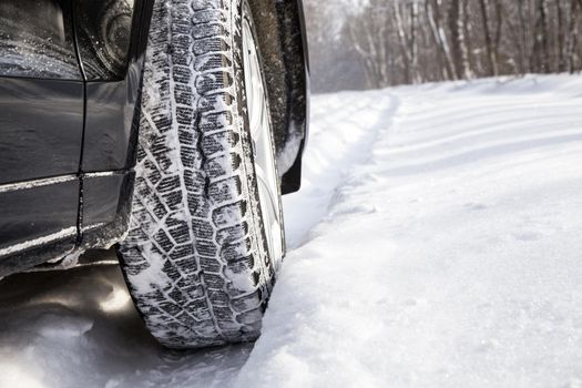 Driving SUV car in winter on forest road with much snow
