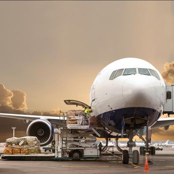 Loading cargo on the plane in airport, view through window