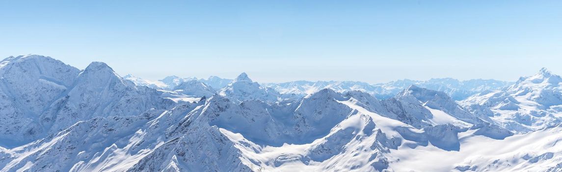 White snowy winter Caucasus mountains at sunny day. Panorama view from ski slope Elbrus, Russia with sky background