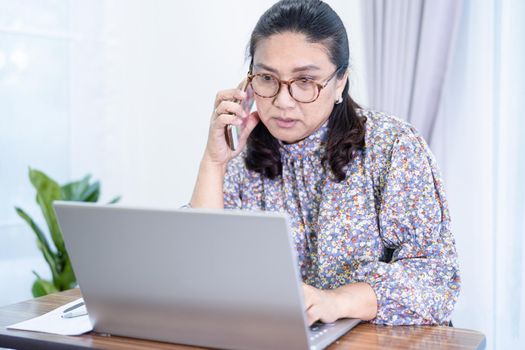 Asian lady businesswoman work from home communicate to office by conference video call on laptop, stay at home.