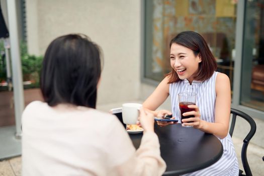 Women friends gossiping during coffee time.