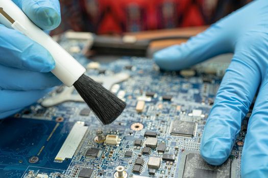 Technician use brush and air blower ball to clean dust in circuit board computer. Repair upgrade and maintenance technology.