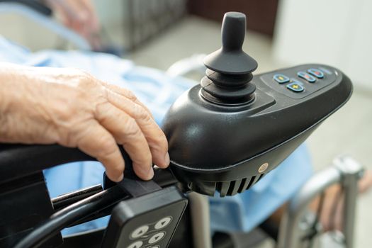 Asian senior or elderly old lady woman patient on electric wheelchair with remote control at nursing hospital ward, healthy strong medical concept