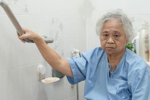 Asian senior or elderly old lady woman patient use toilet bathroom handle security in nursing hospital ward, healthy strong medical concept.