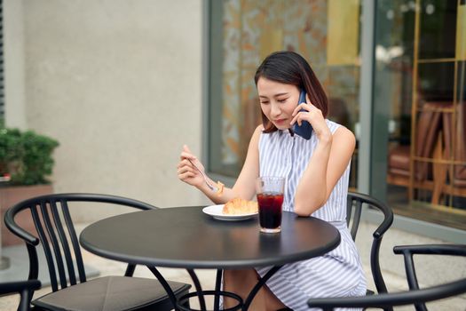 Elegant girl calling someone while resting in outdoor cafe