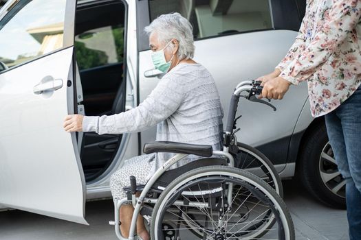 Help and support asian senior or elderly old lady woman patient sitting on wheelchair prepare get to her car, healthy strong medical concept.