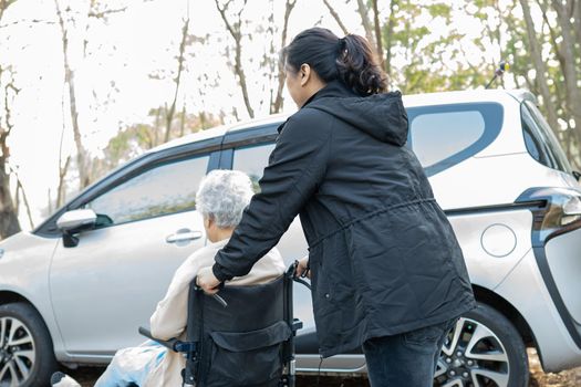 Help and support asian senior or elderly old lady woman patient sitting on wheelchair prepare get to her car, healthy strong medical concept.