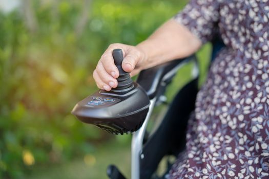 Asian senior or elderly old lady woman patient on electric wheelchair with remote control at nursing hospital ward, healthy strong medical concept