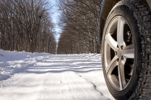 Driving SUV car in winter on forest road with much snow