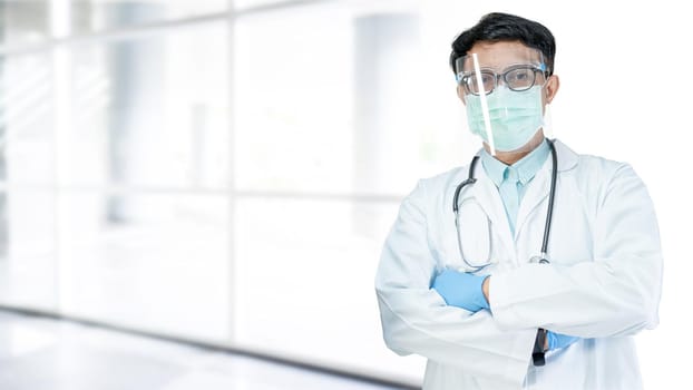 Asian doctor wearing face shield and PPE suit new normal to check patient protect safety infection Covid-19 Coronavirus outbreak at quarantine nursing hospital; for header banner