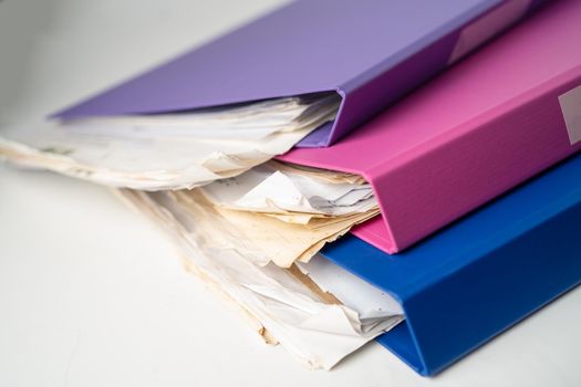 File Folder Binder stack of multi color on table in office.