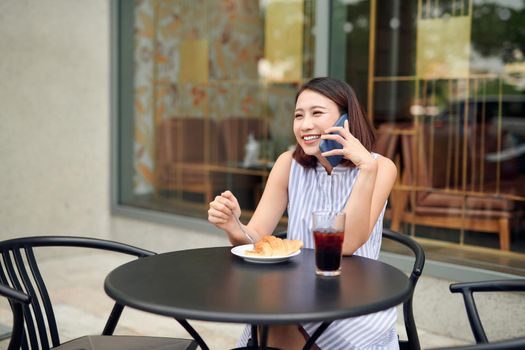 Elegant girl calling someone while resting in outdoor cafe