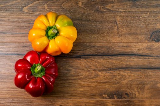 red and yellow peppers on wooden table top