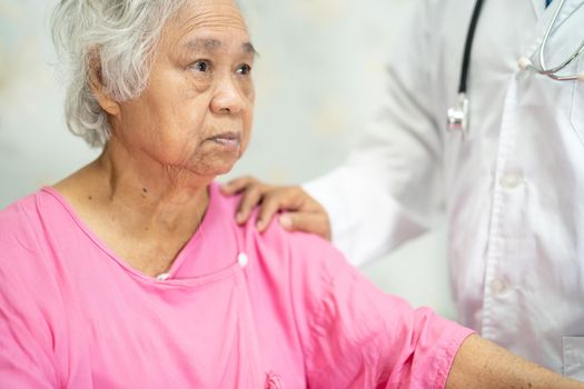 Asian doctor touching Asian senior or elderly old lady woman patient with love, care, helping, encourage and empathy at nursing hospital ward, healthy strong medical concept.