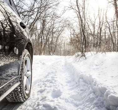 Driving SUV car in winter on forest road with much snow