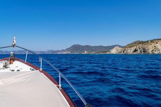 Beautiful view of the southern Sardinian sea from the boat. Note the historic Saracen tower on the rock formations.