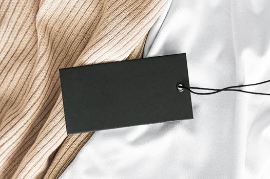 Black horizontal price tag on luxury fabric background.