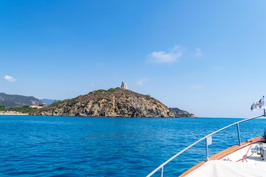 Beautiful view of the southern Sardinian sea from the boat. Note the historic Saracen tower on the rock formations.