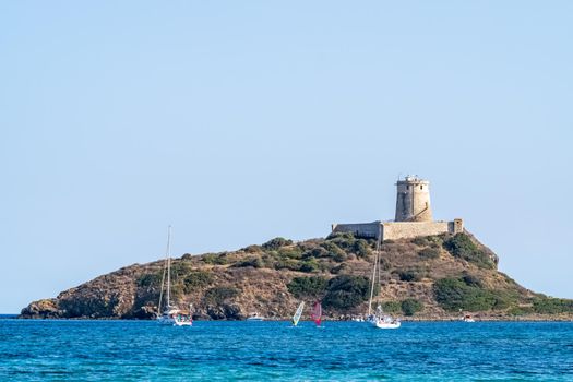 Beautiful view of the southern Sardinian sea from the boat. Note the historic Saracen tower on the rock formations.