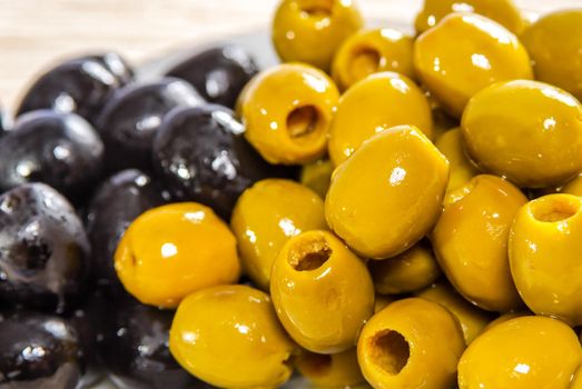 Pitted green and black olives on plate
