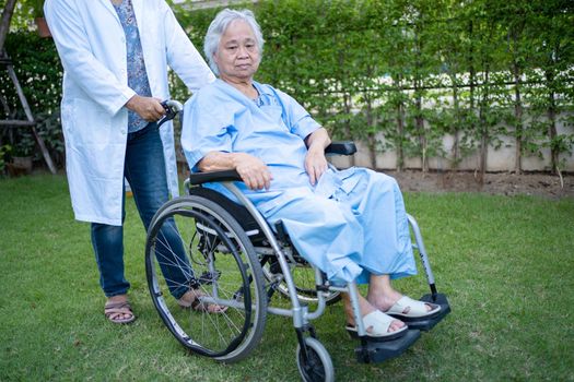 Doctor help and care Asian senior or elderly old lady woman patient sitting on wheelchair at park in nursing hospital ward, healthy strong medical concept.