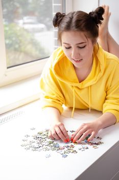 Young Woman trying to match pieces of a Jigsaw Puzzle Game. Playing board game