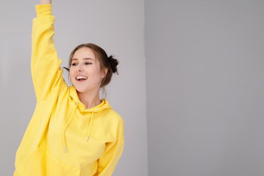 happy positive brunette in yellow hoodie in bright room. happy people. millennial generation. fashionable teenager. trendy colours.