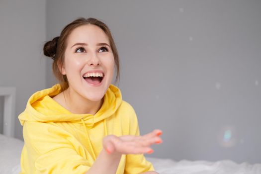 happy positive brunette in yellow hoodie in bright room. happy people. millennial generation. fashionable teenager. trendy colours.