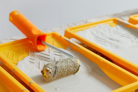 Closeup view of paint tray filled with gray paint. Tools for the painter and redecoration. Interior renovation concept