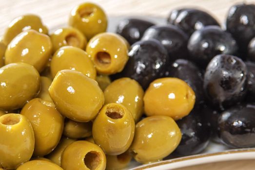 Pitted green and black olives on plate