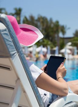 woman on sunbed waering beautiful pink hat