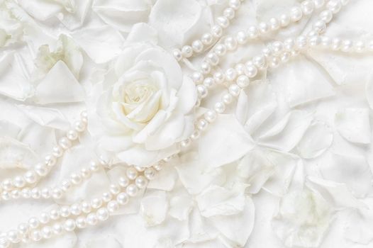 Beautiful white rose and pearl necklace on a background of petals. Ideal for greeting cards for wedding, birthday, Valentine's Day, Mother's Day