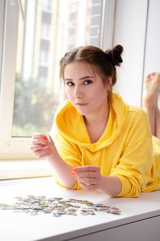 Young Woman trying to match pieces of a Jigsaw Puzzle Game. Playing board game