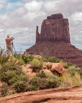 Hiker photographer taking picture of the Monument Valley from view point