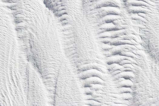 Abstract gray and white texture of Pamukkale calcium travertine in Turkey, vertical pattern, close-up.