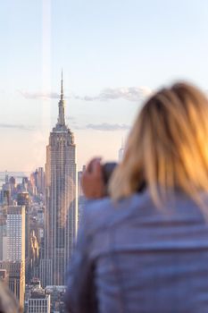 New york, USA - May 17, 2019: Rear View of Woman Peering Through Binocular View Finder at New York City Skyline from Top of the Rock