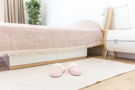 Bedroom in modern style with pink cozy soft slippers on floor