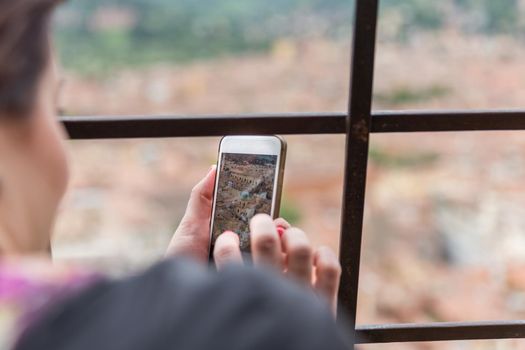 Taking picture of Bologna with cellphone from top of tower