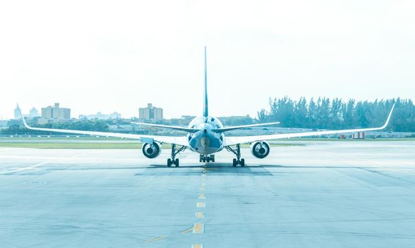 Back view of airplane standing on runway at aerodrome