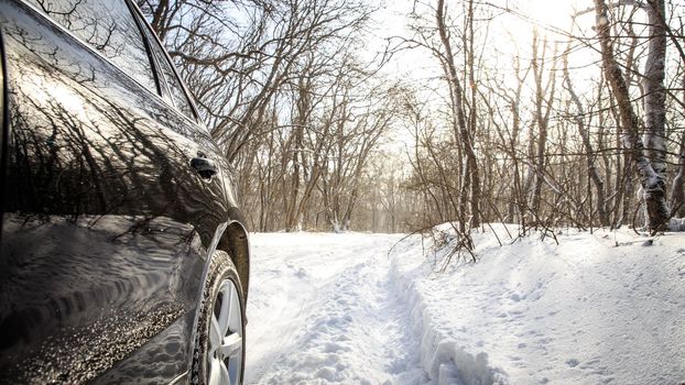 Driving SUV car in winter on forest road with much snow