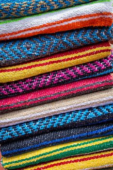 Colorful striped woollen rugs selling on a street