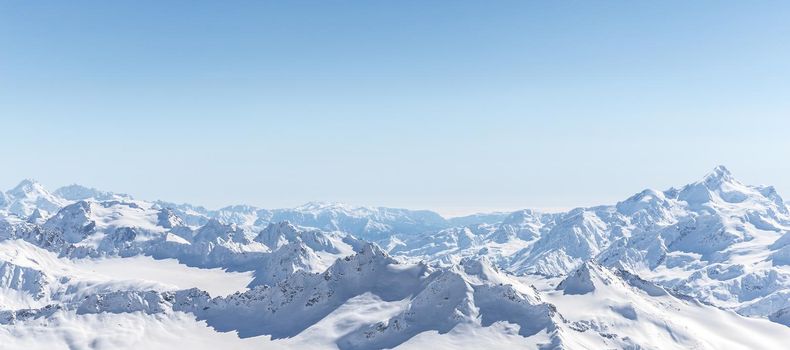 White snowy winter Caucasus mountains at sunny day. Panorama view from ski slope Elbrus, Russia with sky background