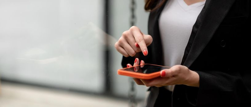 Close up business woman hands touching on smart phone.