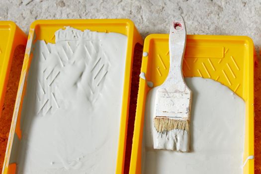 Closeup view of paint tray filled with gray paint. Tools for the painter and redecoration. Interior renovation concept