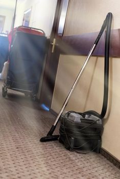 Vacuum cleaner next to a wall in a hotell corridor