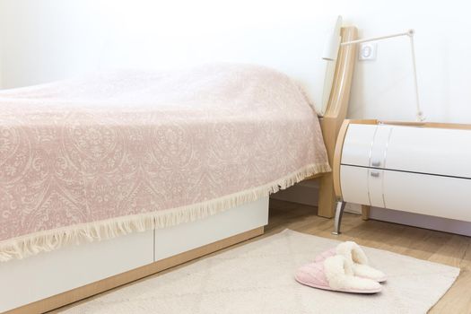 Bedroom in modern style with pink cozy soft slippers on floor