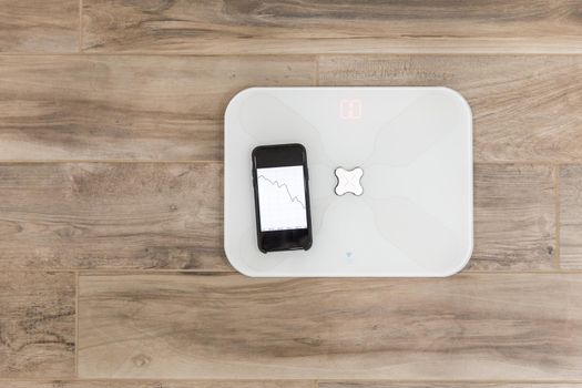 Smart scale standing on a floor connected to smartphone